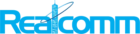 Realcomm logo in blue, with a stylized skyscraper forming the 'l' and an orbit-like ring circling the building.".