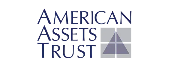 American Assets Trust logo with the company name in blue capital letters and a stylized triangle graphic on a grid background to the right of the text.