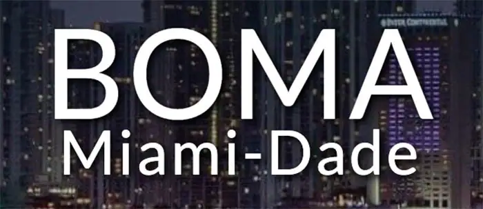 White text reads "BOMA Miami-Dade" over a backdrop of city buildings at night, with windows lit up in the background.